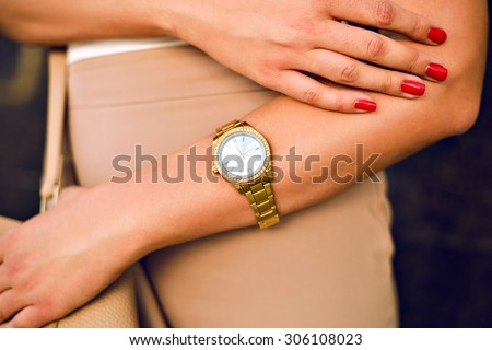Close up image of woman hand, with stylish gold classic watches, fashion details, young businesswoman, beige golden colors.