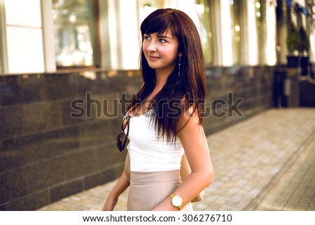 Summer outdoor portrait of stunning elegant woman, wearing classic luxury clothes and accessorizes, posing on the street, warm colors.