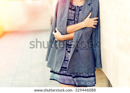 Fashion image of stylish woman wearing grey cashmere coat, black and white dress, soft vintage toned colors, autumn time.
