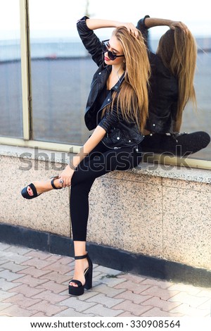 Stylish lady in black, posing outdoor, glamour sexy total black look, hight hells,lather biker jacket, nice autumn day, luxury grunge style.