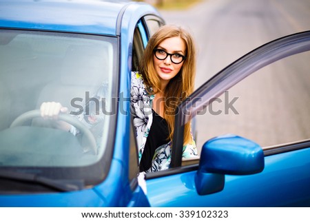 Outdoor lifestyle portrait of young traveler hipster girl driving car, making stop and relax, nice day, travel joy concept.