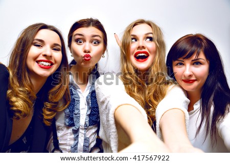 Crazy funny selfie party, four girls having fun at b-day party, stylish black and white clothes. elegant, red lips, funny grimaces, smiling and laughing, making selfie together, toned image with flash