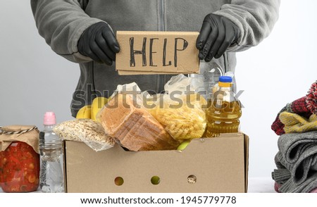 collects food, fruits and things in a cardboard box to help the needy and the poor, the concept of help and volunteering
