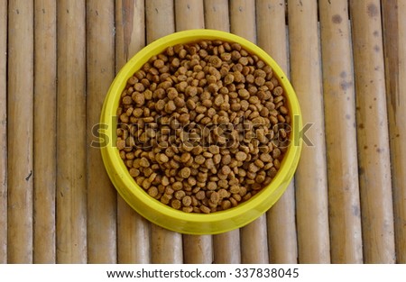 dog food in yellow bowl on bamboo table
