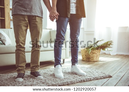Strong relationship. Cropped portrait of two young men standing together on fluffy carpet