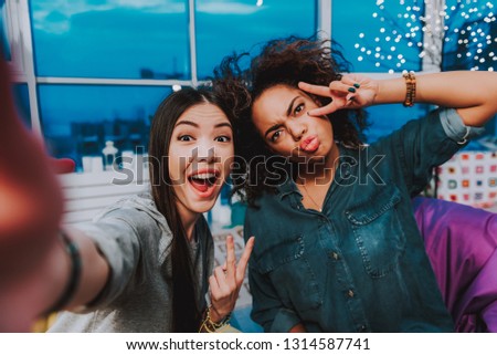 Portrait of asian and african women expressing fun. They clowning at camera. Fun concept