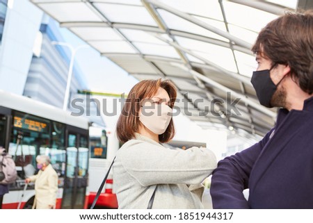 Commuters in local traffic and rush-hour traffic with elbow greeting with face mask