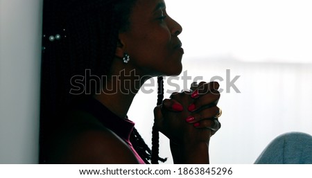 Hopeful woman praying that life will get better. Black African female prayer