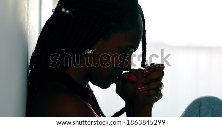 Hopeful woman praying that life will get better. Black African female prayer