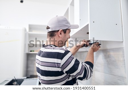 Handyman worker fixing and assembling household furniture.