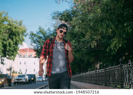 A man tourist walks through the streets with a backpack. A young guy walks alone on European streets