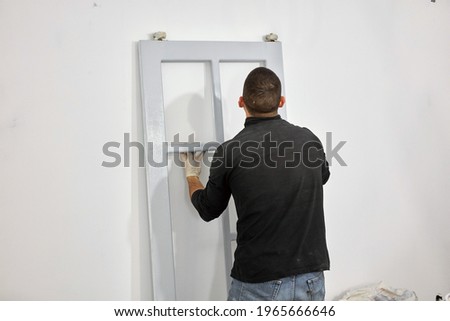 Young adult man restoring on a DIY budget renovation of his new home apartment.