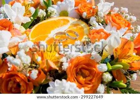 Wedding ring on orange slices in the center of a flower bouquet