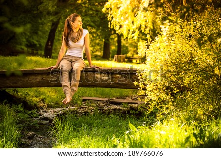 Young attractive female relaxing in nature on beautiful summer day.
