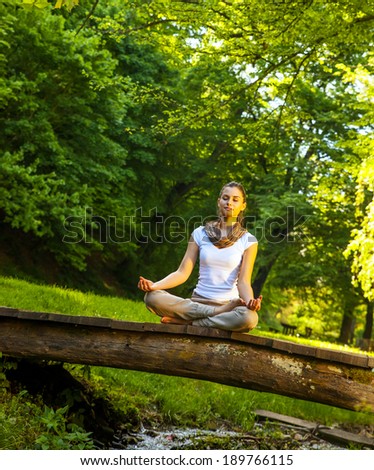 Young attractive woman meditate in nature.