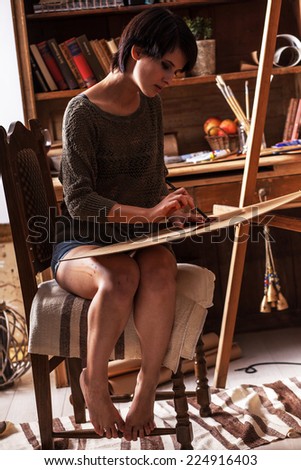 Female artist painter in her studio.Charcoal drawings.