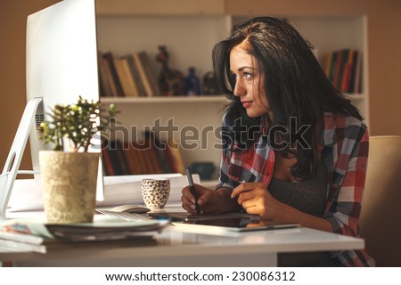 Attractive female working at home.Student.Using digital pen.