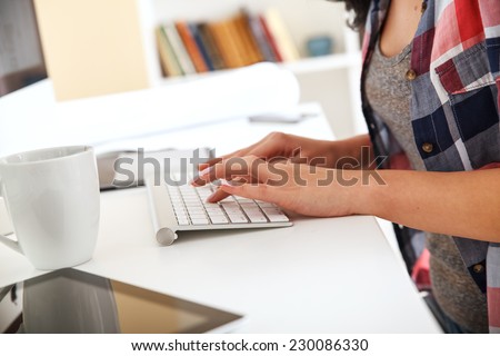 Attractive female working at home.She writing a blog.Hands on the keyboard.
