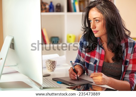 Female architect working at home.She working on computer in her workroom.