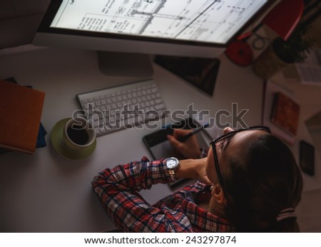 Young female programmer working at home.She works  late into the night.