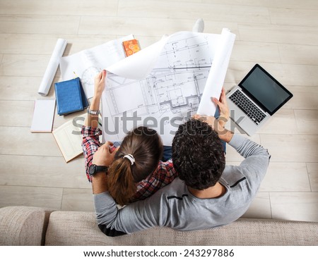Young couple sitting on floor and  calculating about they savings.They plan to invest in new house.View from above.