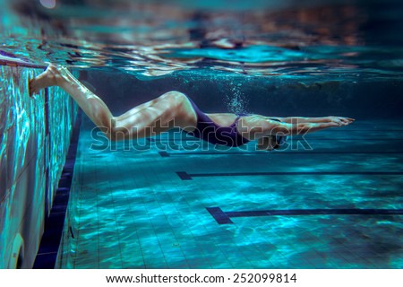 Female swimmer in swimming pool.Underwater image.Grain effect added for artistic impression.
