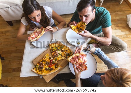 Group of people eating pizza.Image taken from above.