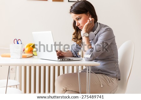 Mid age woman working on her blog.She sitting in he lliving room