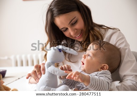 Mother and her baby playing with Bunny toy.