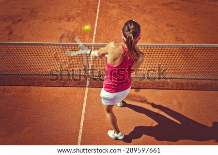 Young woman playing tennis.High angle view.Backhand volley.