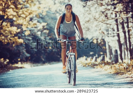 Woman riding a mountain bike in the forest.Grain effect added for artistic impression.