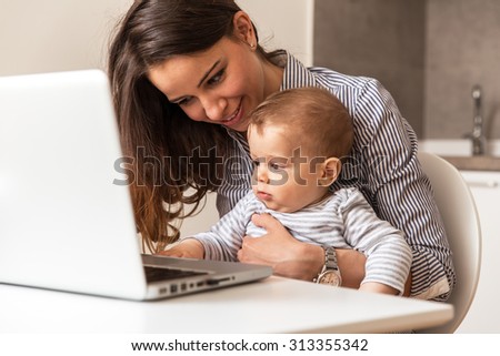 Mother and her baby playing games on internet.