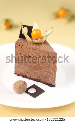 Piece of Chocolate Mousse Cake, on a white plate, on a yellow background.