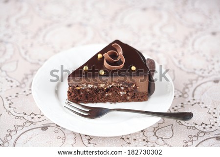 Piece of Chocolate Mousse Cake, on a white plate and light background.