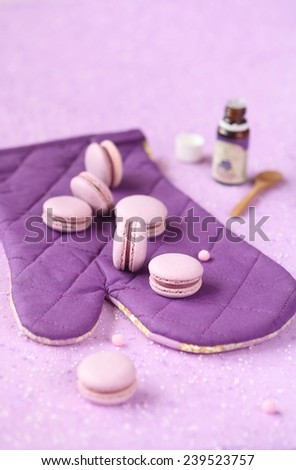 Violet Macarons with Blueberry Cream Filling on a purple pot holder, on a light purple background.