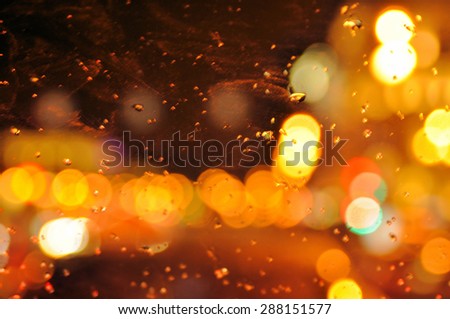 Image of raindrops on window at night in city