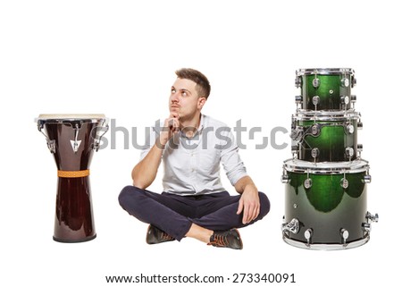 The guy between the djembe and drums on a white background does not know what to choose