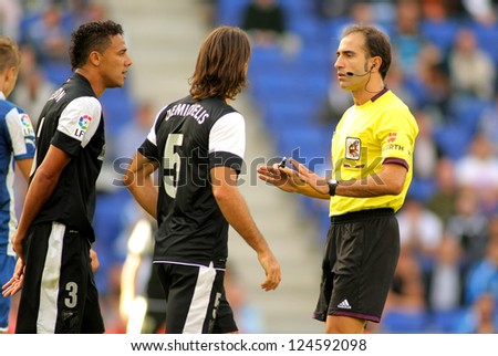 BARCELONA - OCT, 27: Demichelis and Welington of Malaga discuss with the referee Delgado Ferreiro during a Spanish match against Espanyol at the Estadi Cornella on October 27, 2012 in Barcelona, Spain