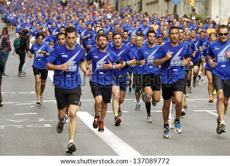 BARCELONA - APRIL, 21: Barcelona street crowded of athletes running during Bombers Race in Barcelona April 21, 2013 in Barcelona, Spain