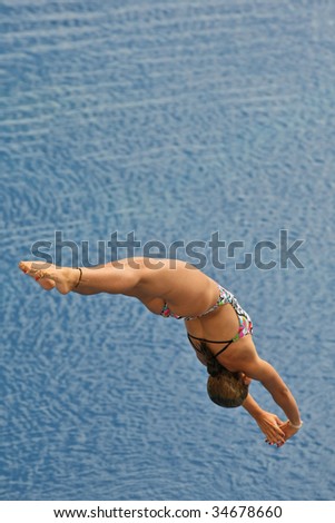 Girl diving into blue waters in a competition