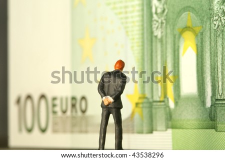A one hundred euro bill with a figure of a man walking around and worrying.