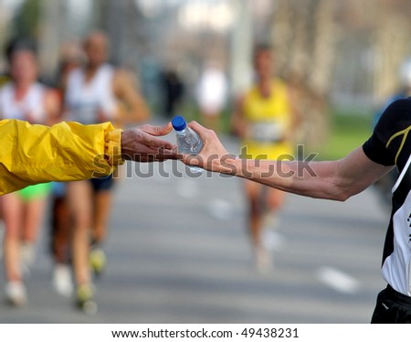 Runner take a bottle of water in a long distance race