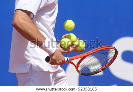 Tennis player checking balls on the racket