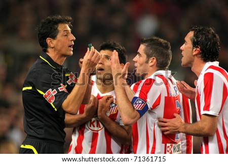 BARCELONA - FEB 5: Atletico Madrid players discuss with the referee Turienzo Alvarez during the match between FC Barcelona and Atletico at the Nou Camp Stadium on February 5, 2011 in Barcelona, Spain