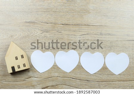 Paper heart shape and wooden house and have copy space for design in love and valentine concept.
