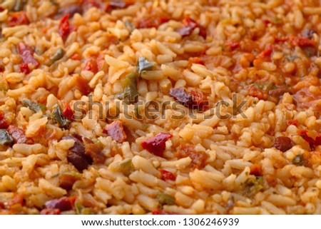 Close side view of cooked Mexican rice and beans in a skillet illuminated with natural lighting.