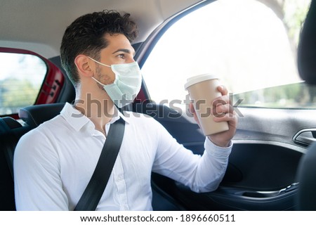 Businessman drinking coffee in car.