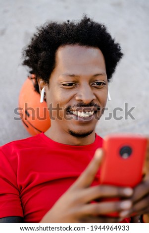 Athletic man using his mobile phone outdoors.