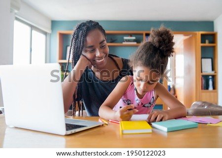 A mother helping her daughter with homeschool.