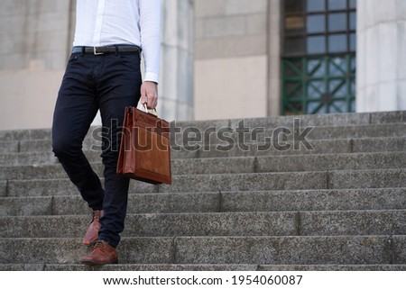 Businessman holding a briefcase outdoors.